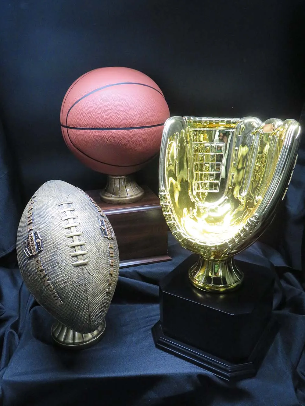 baseball glove, football and basketball trophies